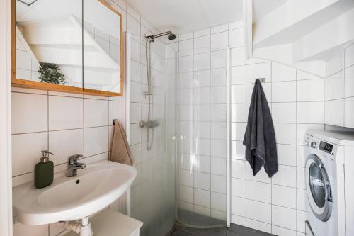 een badkamer met een wastafel en een wasmachine bij Mellomila 69 in Trondheim
