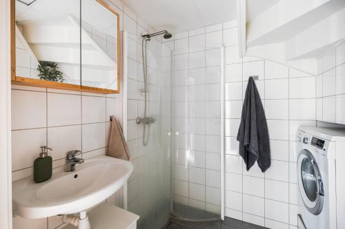 a bathroom with a sink and a washing machine at Mellomila 69 in Trondheim