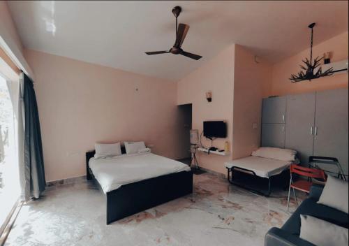 1 Schlafzimmer mit 2 Betten und einem Deckenventilator in der Unterkunft Blue Valley Estate-12 Acre Forest-Silver Oak-Villa in Yercaud
