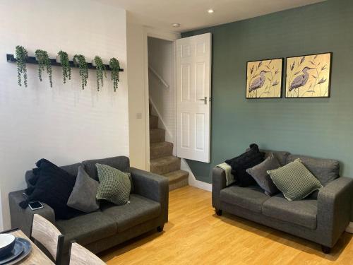a living room with two couches and a staircase at Elegant 4 Bed House - 5 minutes from Leeds in Headingley