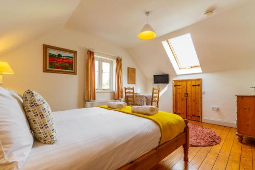 Un dormitorio con una cama grande y una ventana en The Nest, en Wells-next-the-Sea