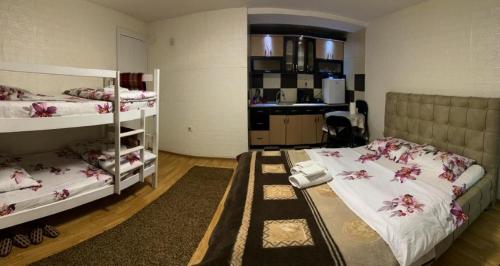 a bedroom with two bunk beds and a kitchen at APARTMENT Marash in Prizren