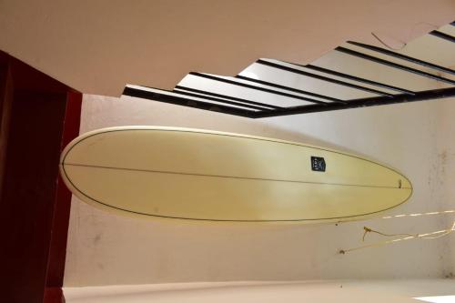uma prancha de surf pendurada no tecto de um quarto em Abraham Beach House em Cananor