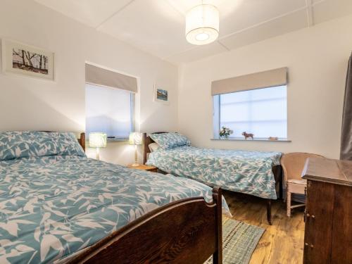 a bedroom with two beds and a window at 3 Bed in Widemouth Bay 77815 in Marhamchurch