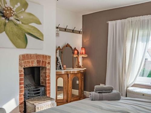 1 dormitorio con chimenea, 1 cama y espejo en 5 Bed in Swaffham 59799, 