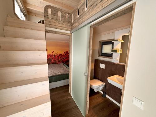 La petite salle de bains est pourvue de toilettes et d'un lavabo. dans l'établissement Tiny Haus Park Fritzlar, à Fritzlar