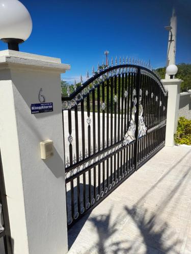 a black metal fence with a lighthouse in the background at Retreat Guest House in Falmouth