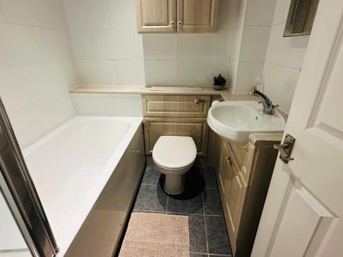a small bathroom with a toilet and a sink at Wimbledon Elegance: 2-bedroom Retreat in London