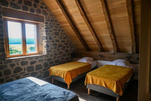 dwa łóżka w pokoju z oknem w obiekcie Buron de Léon, en plein cœur de l Aubrac w mieście Laguiole