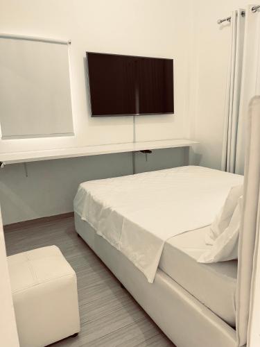 a hospital room with a bed and a flat screen tv at polana apartments in Maputo