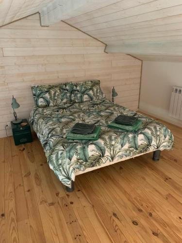 a bedroom with a bed and a wooden floor at Piaf at Bassinaud in Juignac
