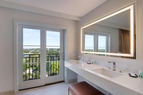 baño con 2 lavabos y espejo grande en The Westin Dallas Stonebriar Golf Resort & Spa, en Frisco