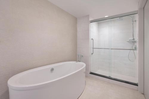 a white bathroom with a tub and a shower at The Westin Dallas Stonebriar Golf Resort & Spa in Frisco