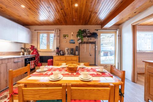 une cuisine avec une table en bois et des chaises ainsi qu'une salle à manger dans l'établissement Le Marmotton, à La Giettaz