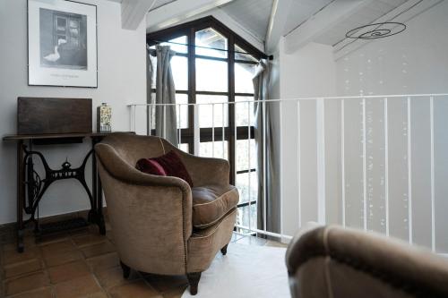 uma sala de estar com uma cadeira e uma janela em Casa Kiko Pecetto em Pecetto