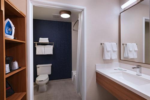 Fairfield Inn & Suites Kansas City Airport في كانساس سيتي: حمام مع حوض ومرحاض ومرآة