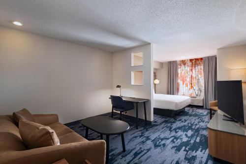 a hotel room with a couch and a bed at Fairfield Inn & Suites Kansas City Airport in Kansas City