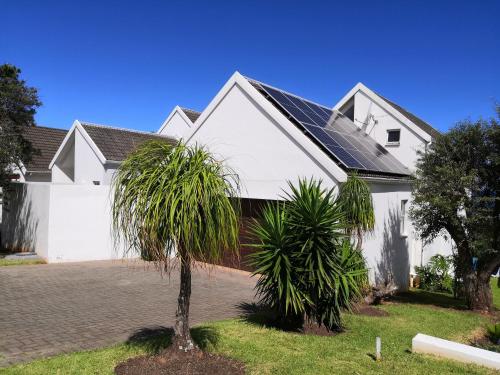 a white house with a palm tree in front of it at Ungabona in East London