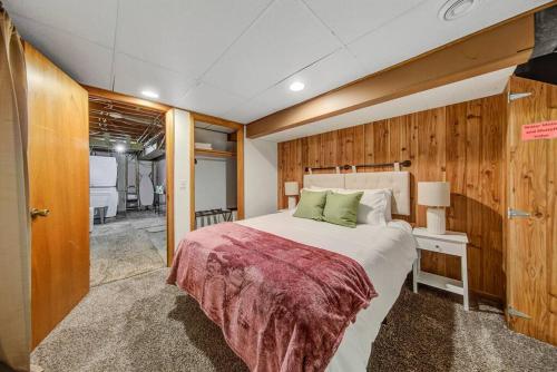 a large bed in a room with wooden walls at Poker/Game Room - BBQ - Backyard fun in Minneapolis