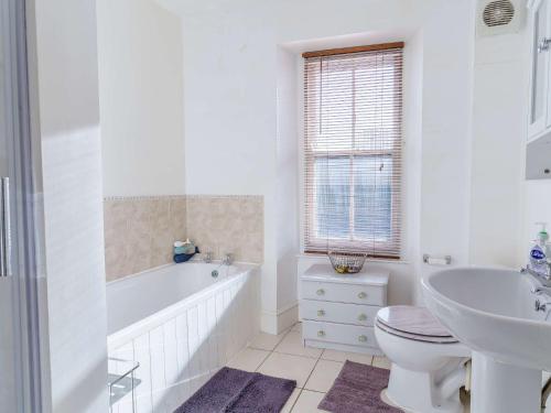a bathroom with a tub and a toilet and a sink at 4 Bed in Pembroke 85835 in Pembroke