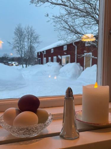 a bowl of eggs and a candle on a window sill at Gamla gården i Ersmark Umeå in Umeå