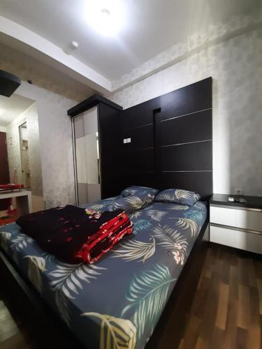 a bed in a bedroom with a red object on it at Inapin Aja by Dio Property in Bandung