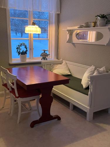 a living room with a table and a couch and a table and a table at Gamla gården i Ersmark Umeå in Umeå