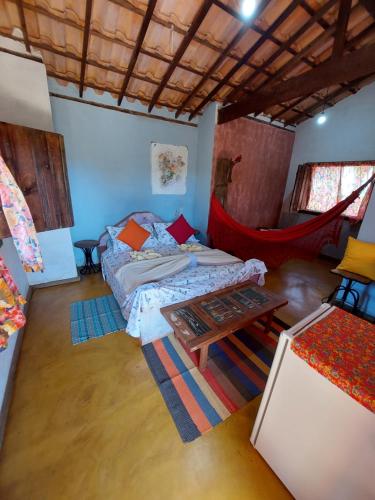 サンタナ・ド・リアーショにあるPousada Casa do Arcoのベッド1台とハンモックが備わる客室です。