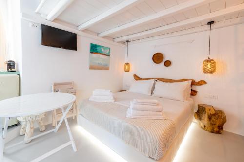 una habitación blanca con una cama y una mesa en MYKONOS VIBES TOWN LOFT, en Mykonos ciudad