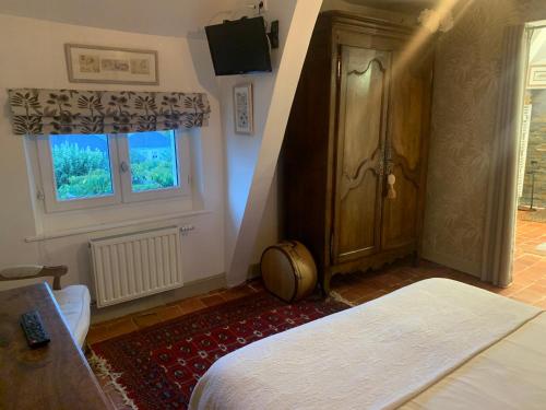 um quarto com uma cama, uma porta e uma janela em Le Clos Mademoiselle em Loches