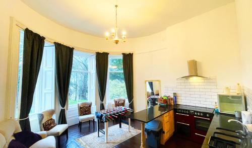 una cucina con scrivania in una camera con finestre di Catcune Suite - Four Bedroom Split Level Apartment a Gorebridge