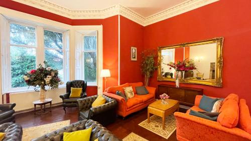 un soggiorno con mobili arancioni e specchio di Catcune Suite - Four Bedroom Split Level Apartment a Gorebridge