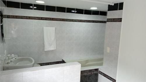 een badkamer met een wastafel, een bad en een toilet bij CASA HOTEL BOTERO in Medellín