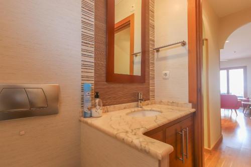 y baño con lavabo y espejo. en 022 - Las Palmeras III - 001 - comfortHOLIDAYS, en Santa Pola