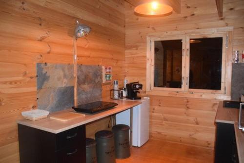 eine Küche mit einer Theke in einer Holzhütte in der Unterkunft Chalet Bois Joli in Herry