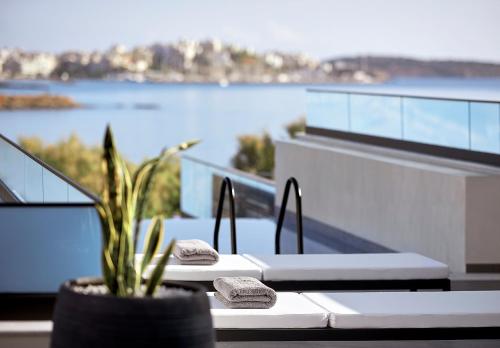 a table with two towels and a plant on a balcony at The Sand Villa in Agios Nikolaos