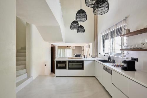 a white kitchen with a sink and a stove at The Sand Villa in Agios Nikolaos