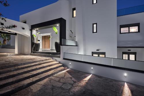 a white building with a staircase in front of it at The Sand Villa in Agios Nikolaos