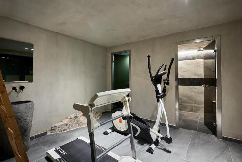 a room with a gym with a treadmill and a room with a shower at The Sand Villa in Agios Nikolaos