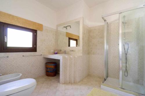 a bathroom with a shower and a sink and a toilet at Villa Greta By Vivimy in Parabita