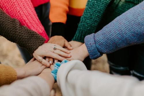 a group of people putting their hands on top of each other at First Hotel Millennium in Oslo