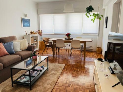 ein Wohnzimmer mit einem Sofa und einem Tisch in der Unterkunft Estoril 2 bedrooms by the Beach in Estoril