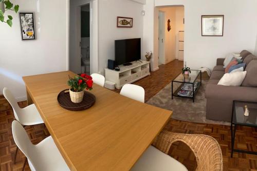 ein Wohnzimmer mit einem Holztisch und einem Sofa in der Unterkunft Estoril 2 bedrooms by the Beach in Estoril