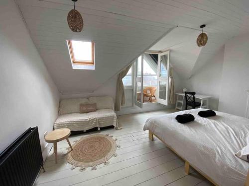 sypialnia na poddaszu z 2 łóżkami i oknem w obiekcie Edwardian Villa by the sea-side w mieście Walton-on-the-Naze