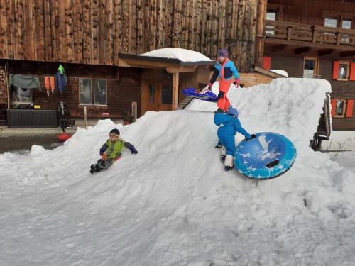 two children are playing in a pile of snow at Haus Peintner in Tannheim