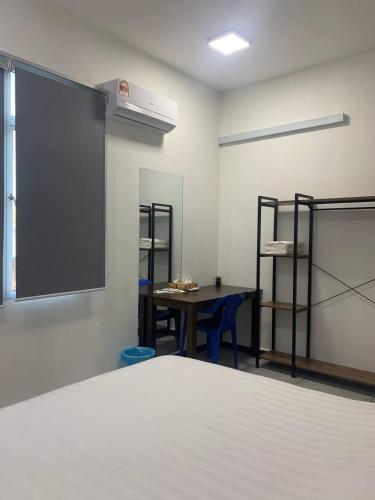 a room with a bed and a table and a window at 365 Homestay in Kaki Bukit