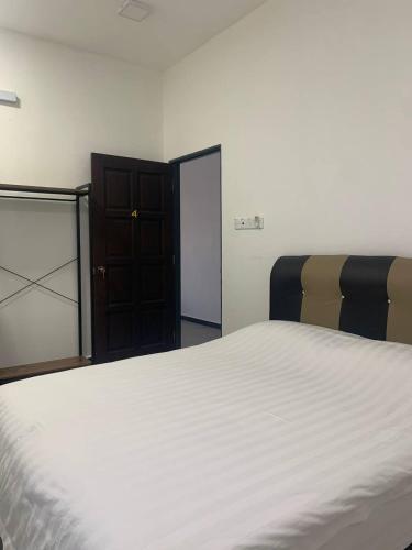 a bedroom with a large white bed and a closet at 365 Homestay in Kaki Bukit