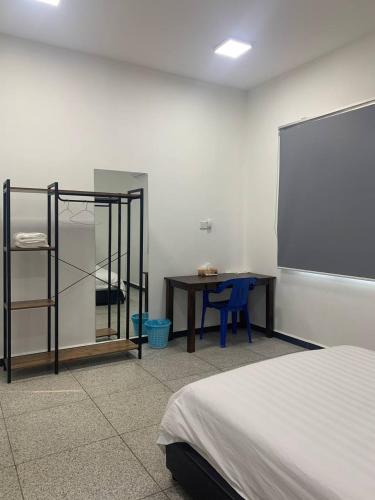 a room with a bed and a table and a mirror at 365 Homestay in Kaki Bukit
