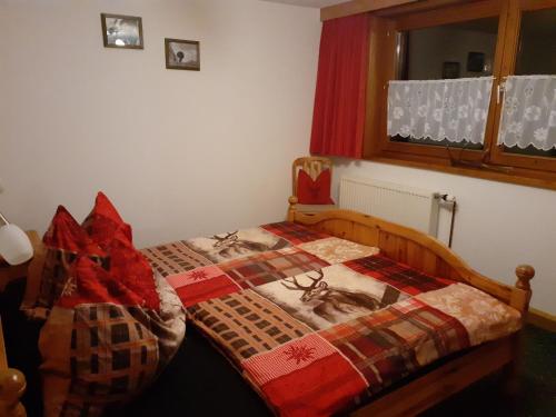 a bedroom with a bed with a quilt on it at Haus Peintner in Tannheim