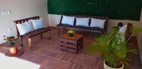 Sala de estar con 2 bancos y mesa en Pousada São Francisco PETAR en Iporanga